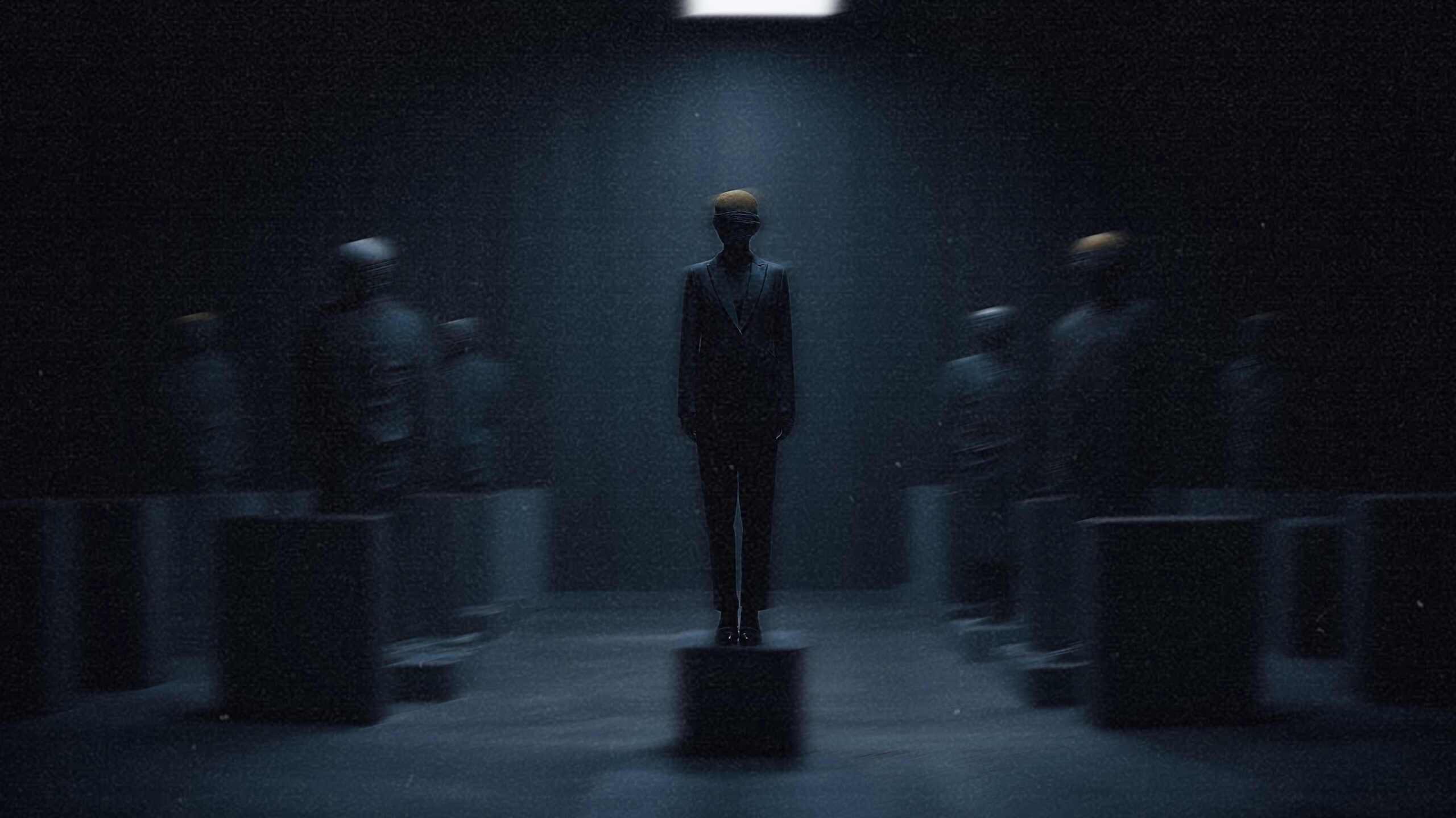 Central figure in a tailored suit stands blindfolded on a pedestal, surrounded by multiple blindfolded statues arranged symmetrically in a dim architectural space
